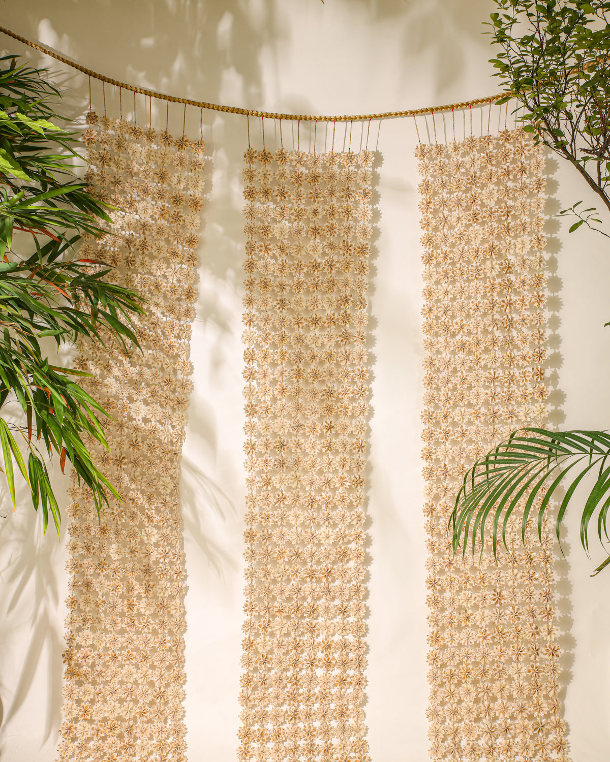 Inspired by the beauty of Raat ki Rani flowers, this handcrafted floral jaal is made from Rani Pink textile remnants, with individually handmade flowers joined by delicate zari knots. Finished with a hand-braided zari border, it is perfect for decorating doorways, walls, and festive spaces.