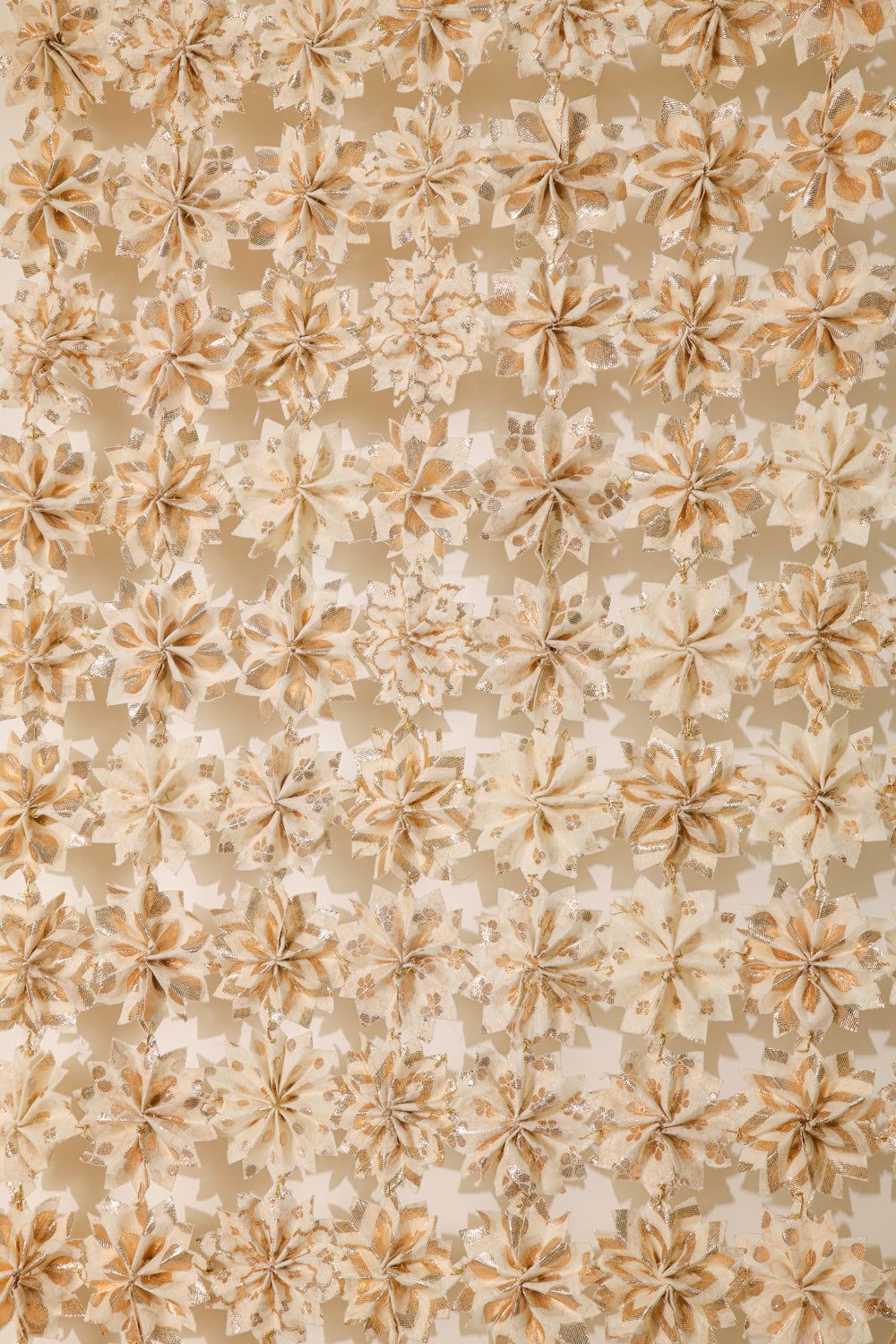 Inspired by the beauty of Raat ki Rani flowers, this handcrafted floral jaal is made from Rani Pink textile remnants, with individually handmade flowers joined by delicate zari knots. Finished with a hand-braided zari border, it is perfect for decorating doorways, walls, and festive spaces.