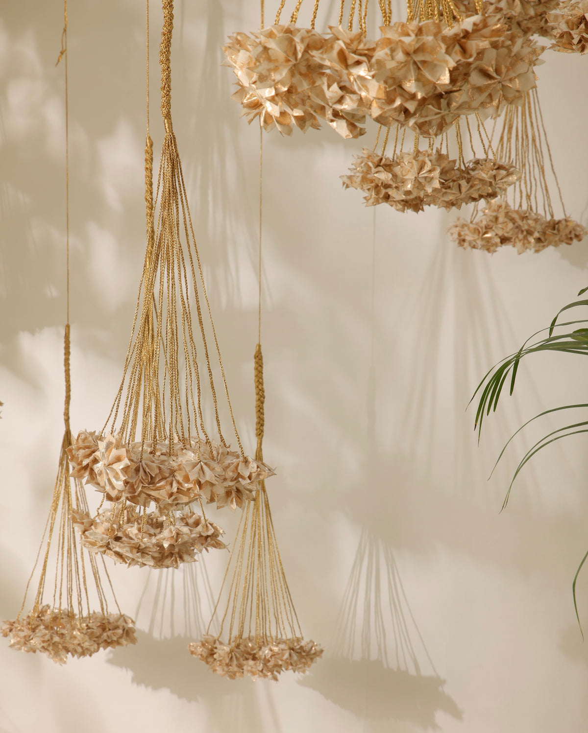 Handcrafted Rani Pink Thousand Flowers hanging featuring ivory origami flowers made from raw Chanderi textiles, suspended from delicate zari and crochet strings.