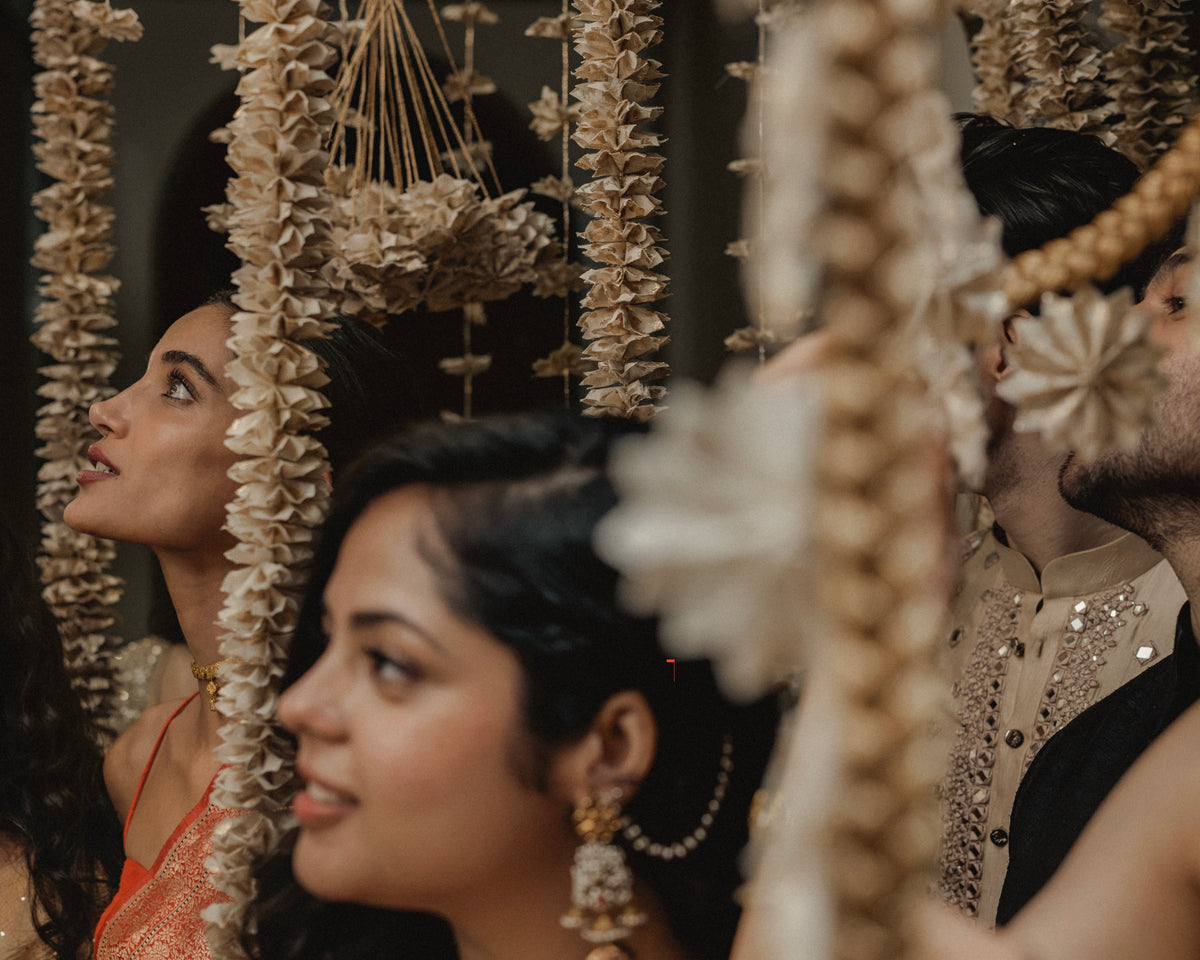 Handcrafted Rani Pink Thousand Flowers hanging featuring ivory origami flowers made from raw Chanderi textiles, suspended from delicate zari and crochet strings.