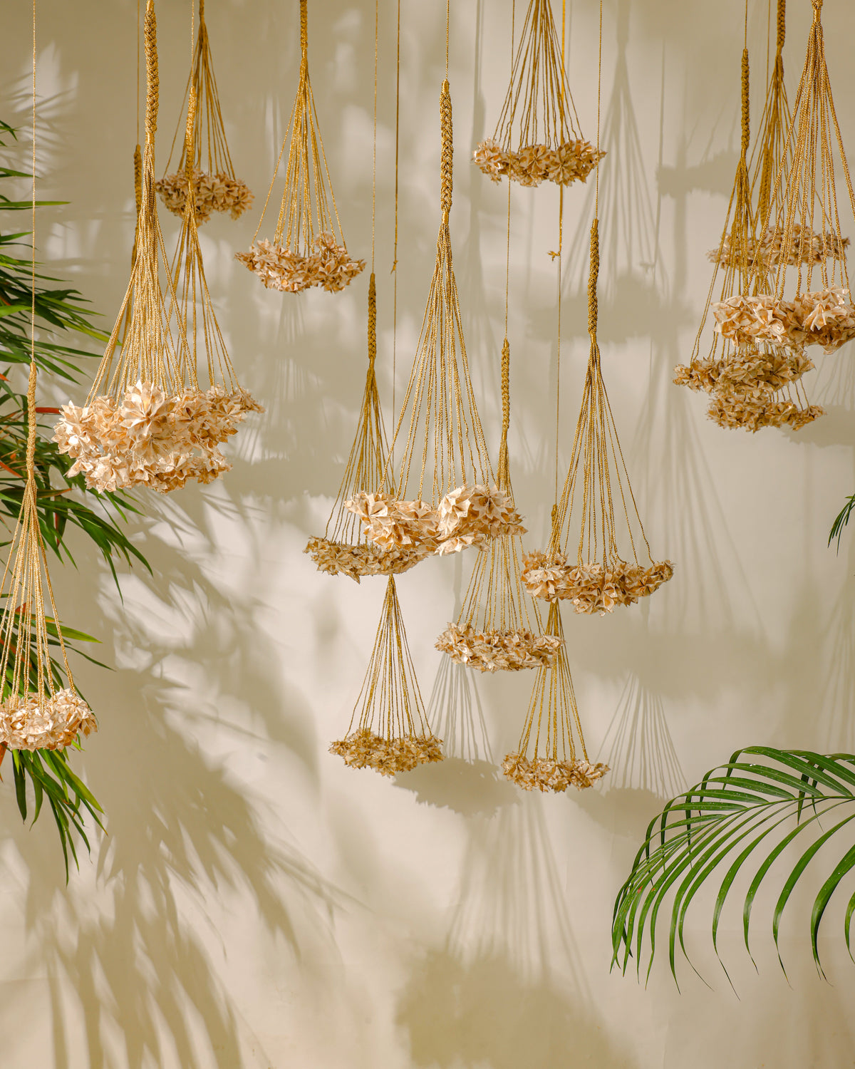 Handcrafted Rani Pink Thousand Flowers hanging featuring ivory origami flowers made from raw Chanderi textiles, suspended from delicate zari and crochet strings.