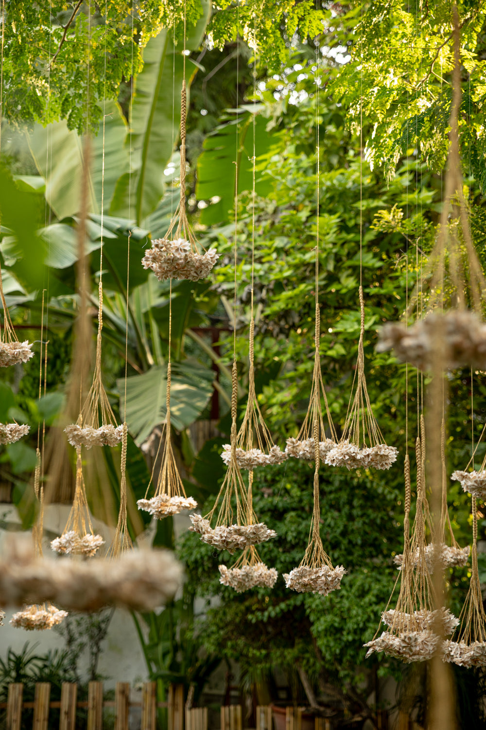 Handcrafted Rani Pink Thousand Flowers hanging featuring ivory origami flowers made from raw Chanderi textiles, suspended from delicate zari and crochet strings.