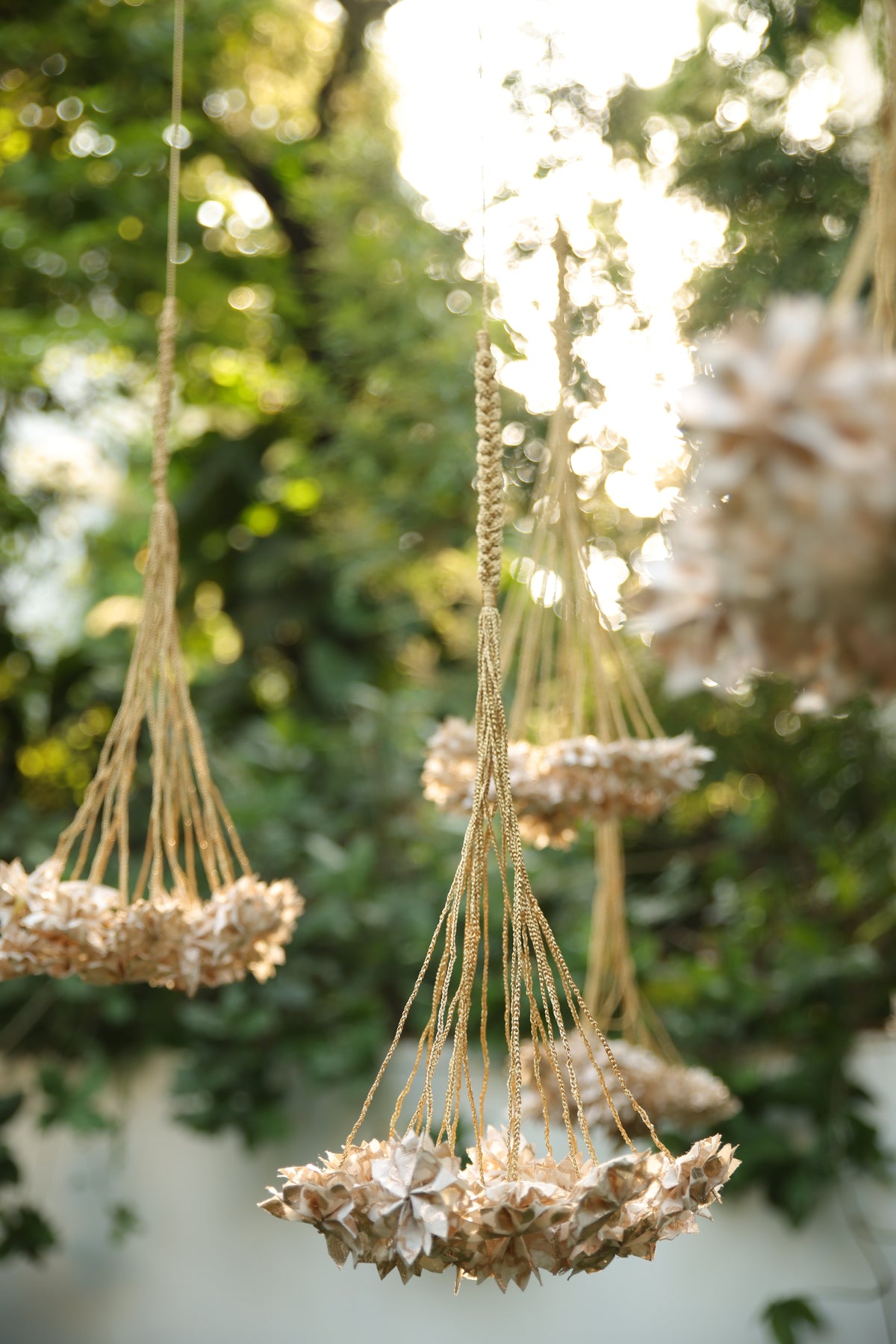 Handcrafted Rani Pink Thousand Flowers hanging featuring ivory origami flowers made from raw Chanderi textiles, suspended from delicate zari and crochet strings.