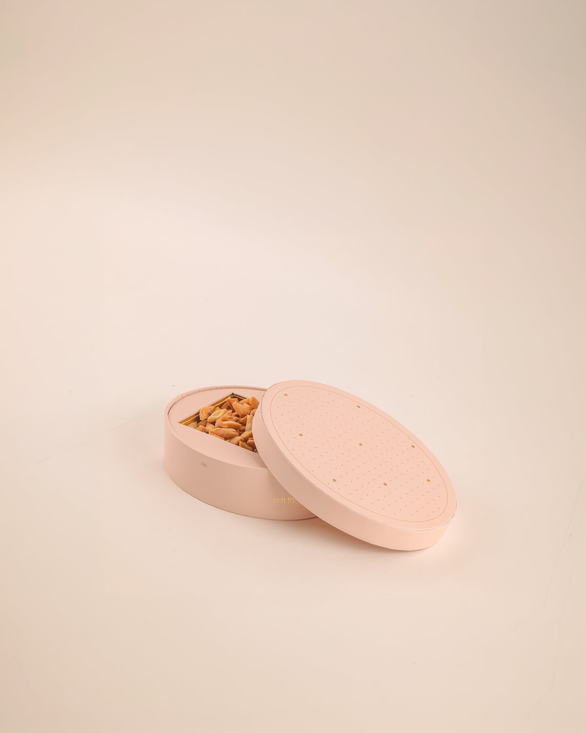 Inspired by old-fashioned mithai boxes, this oval paper sweets box comes in powder pink and pista green, adorned with embossed silver dots and delicate gold Mughal stars. Perfect for gifting mithai, festive treats, and celebrating special moments.